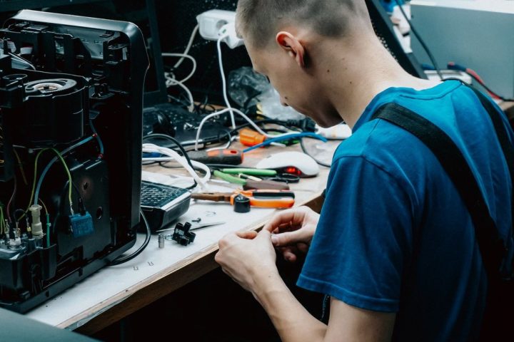 Technicien informatique en alternance réparant un ordinateur