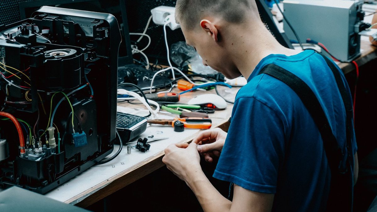 Technicien informatique en alternance réparant un ordinateur