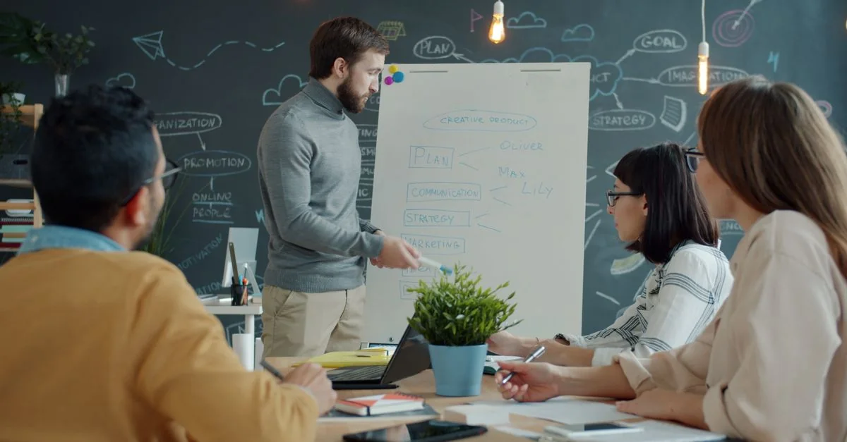 Une équipe discute, dans un environnement de bureau moderne, d'une stratégie de projet créatif.